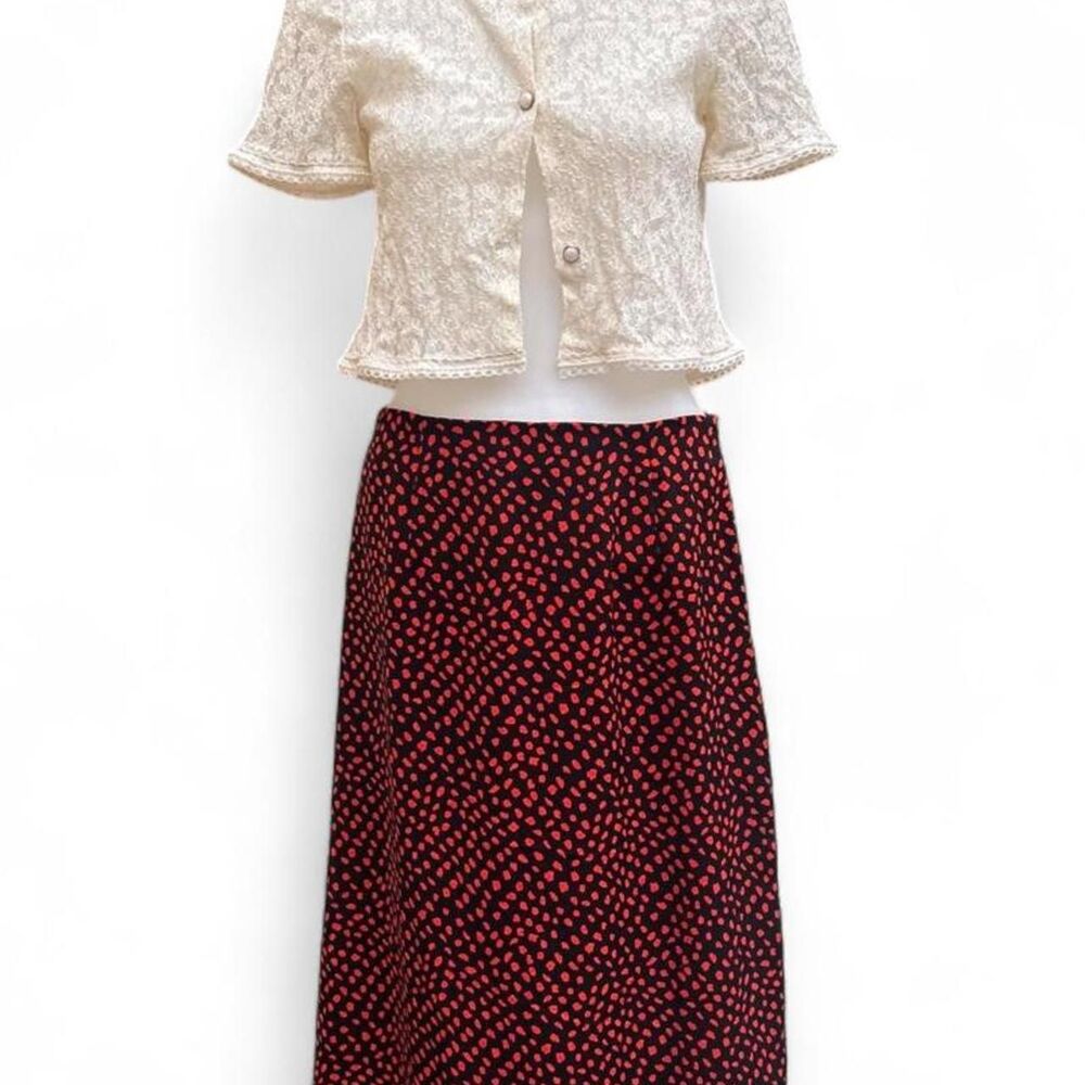Black midi skirt with red splotchy polka dots and a side slit